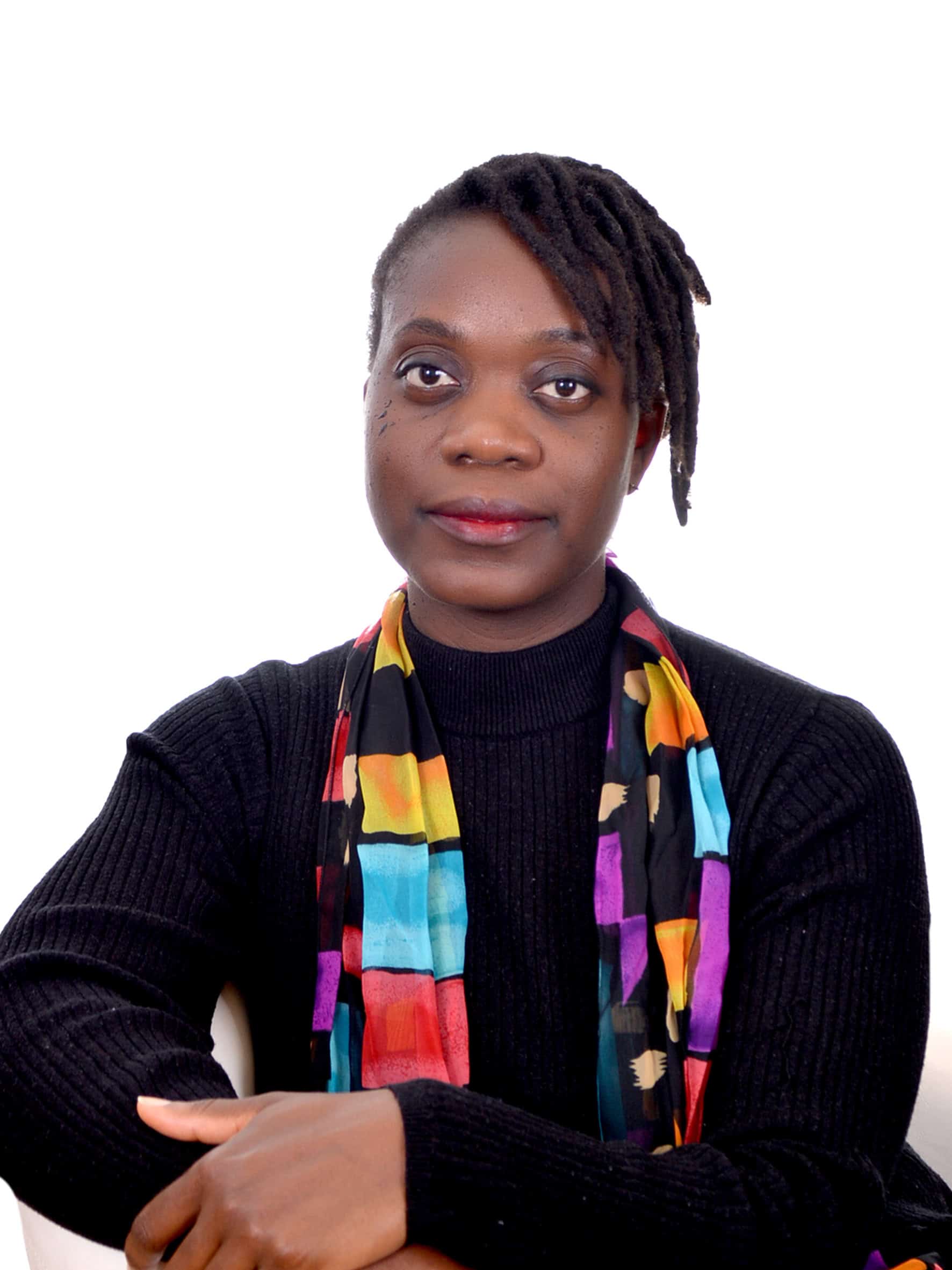 Portrait of Adeola Olatunji with colorful scarf and black sweater.