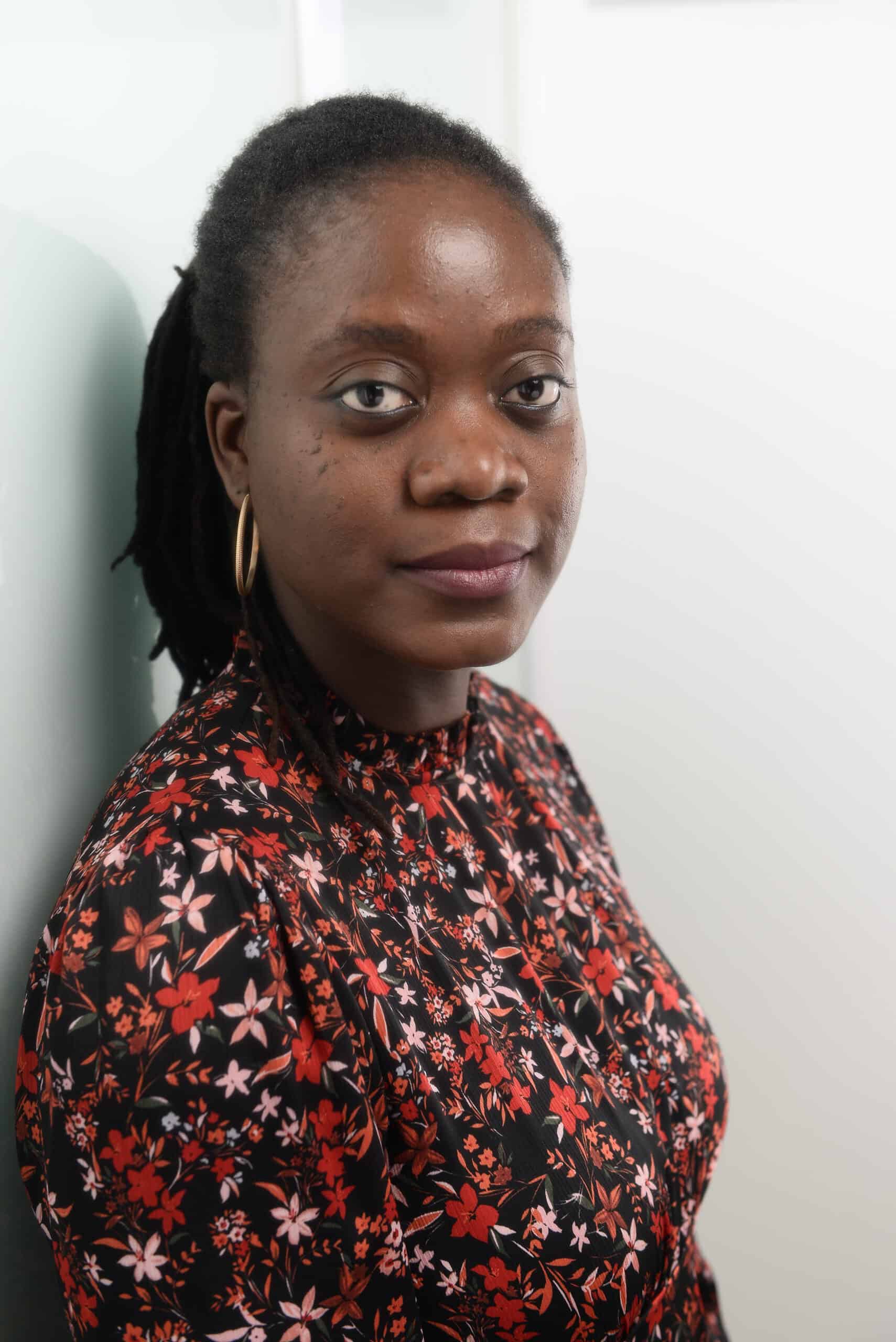 Portrait of Adeola Olatunji, Nigerian woman with natural hair and floral dress.